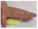 with a flat palm, hand pushes down on a ball of yellow putty